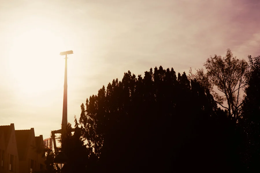Silhouette eines hohen Fahrgeschäfts und von Bäumen im warmen Abendlicht