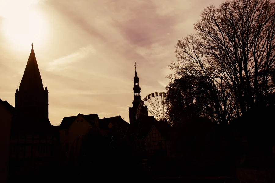 Dunkle Silhouette von Soester Kirchtürmen und Dächern vor warmem Novemberhimmel