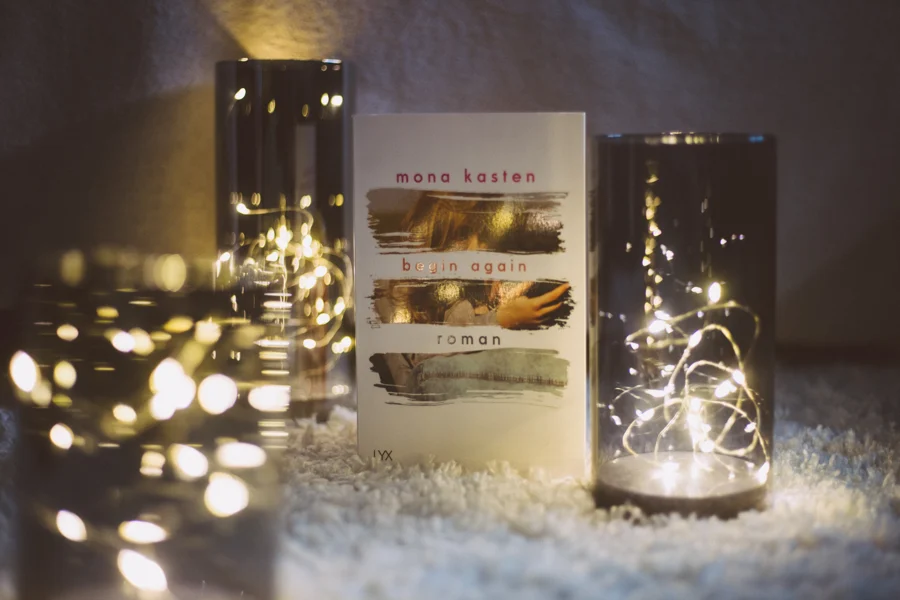 Ein Buch zwischen Gläsern mit warm leuchtenden Lichterketten