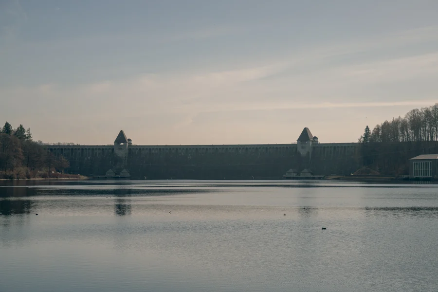 Wasserfläche vor einer langen steinernen Mauer mit kleinen Türmen