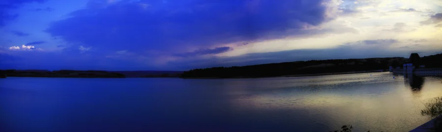 Landschaft mit Feldern, Wasser und weitem Himmel