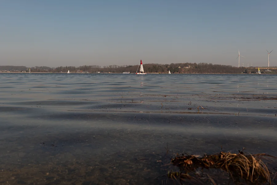 Wasserfläche mit Ufer und weitem Himmel