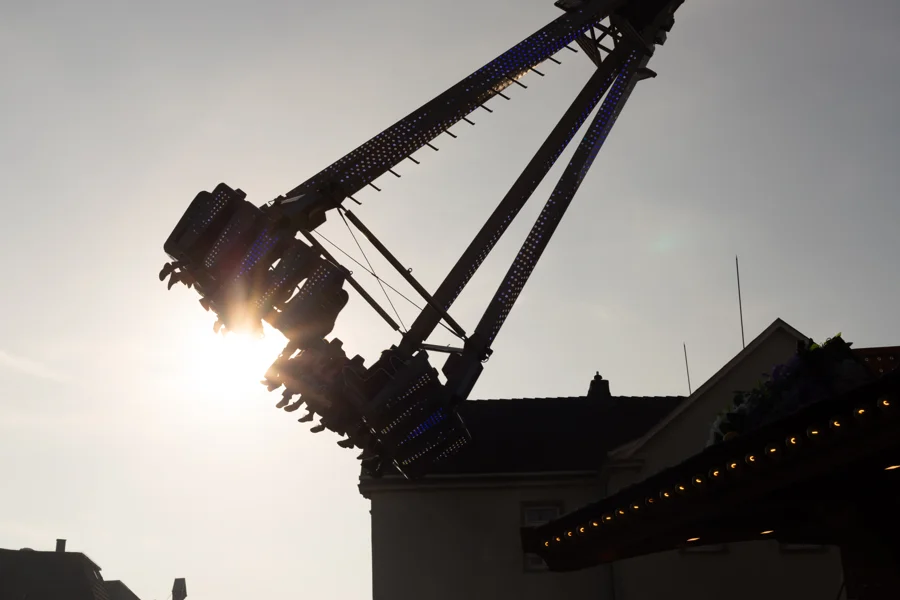 Silhouette eines Fahrgeschäfts im Gegenlicht auf der Kirmes