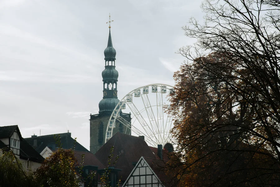 Fahrgeschäfte und historische Gebäude auf der Soester Kirmes