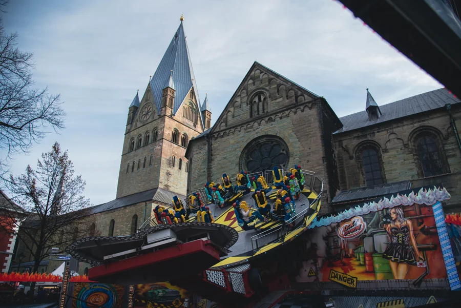 Fahrgeschäfte und historische Gebäude auf der Soester Kirmes